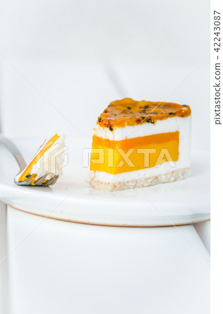Slice of mango passion fruit coconut cake on white 42243087