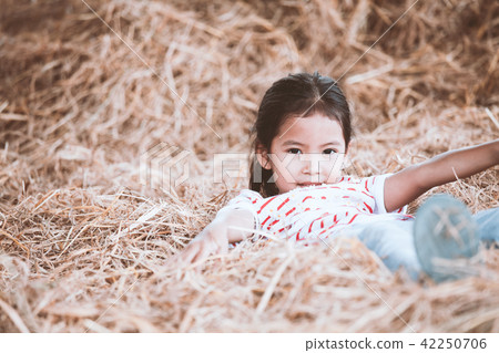 Cute asian child girl lying down on hay 42250706