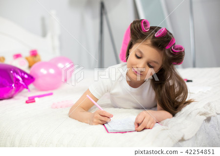 Girl writing in her notebook in bed. 42254851