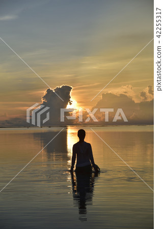 Morning glow of Shiraho Coast and female silhouette 42255317