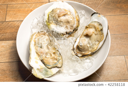 Fresh opened oyster offered as top view. 42258118