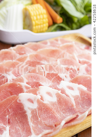 sliced raw pork on wooden plate with vegetables sliced raw pork on wooden plate with vegetables 42258618