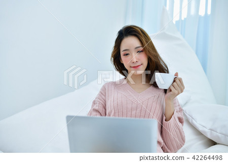 Winter Concept. Women are playing a notebook in the bedroom. Wom 42264498