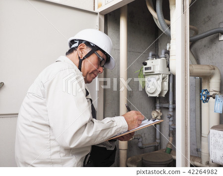 Worker inspecting gas meter 42264982