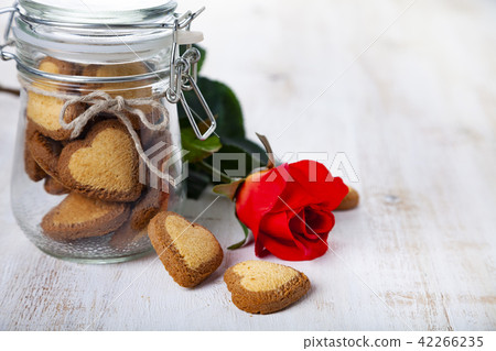 Heart-shaped cookies in a glass jar and red rose 42266235