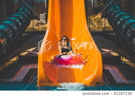 lady going down by the slide in aqua park lady going down by the slide in aqua park 42267136