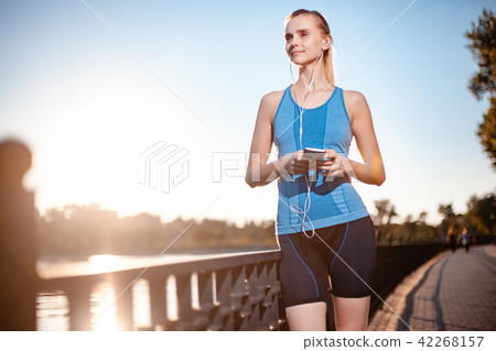 The girl in a t-shirt is standing by the lake The girl in a t-shirt is standing by the lake 42268157