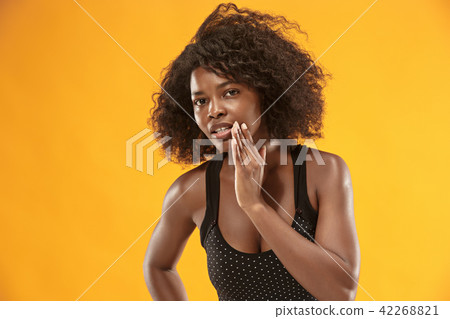 The young woman whispering a secret behind her hand 42268821