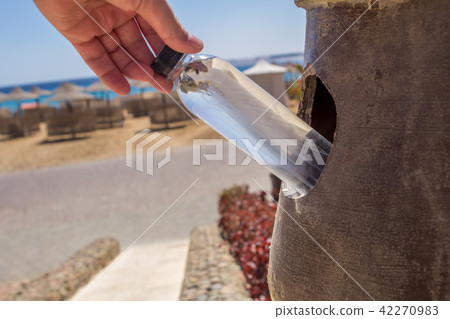 A bottle of water and in a trash can as garbage A bottle of water and in a trash can as garbage 42270983