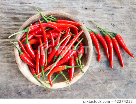 Fresh red hot chili peppers in wood bowl on wooden Fresh red hot chili peppers in wood bowl on wooden 42274232