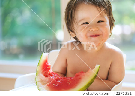 Toddler boy eating watermelon Toddler boy eating watermelon 42275351