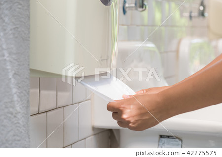 Woman hand pulling a white tissue from tissue box 42275575
