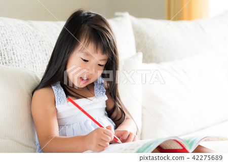 Little girl smiling and holding red pencil Little girl smiling and holding red pencil 42275689