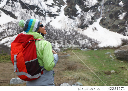Backpacker girl stands on top of a mountain 42281271