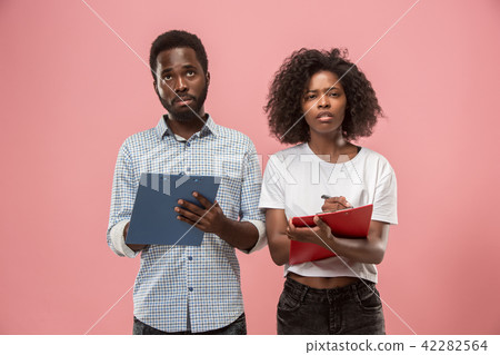 Two african students with folders in t-shirts together. Stylish girl with Afro hairstyle and her 42282564