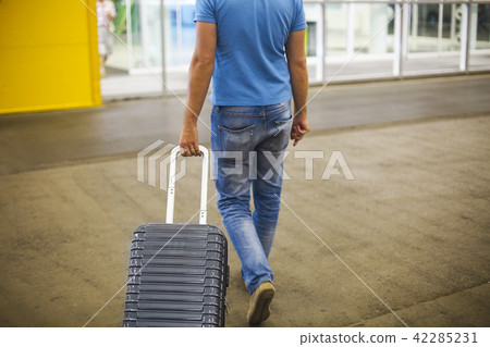 Young man with suitcase at airport or station Young man with suitcase at airport or station 42285231