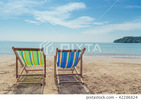 Two beach chairs on the white sand with blue sky Two beach chairs on the white sand with blue sky 42286824