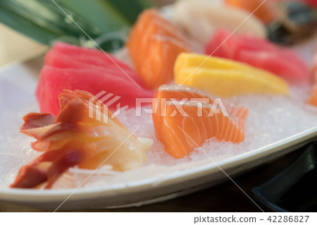 Mixed sliced fish sashimi on ice in white bowl. Mixed sliced fish sashimi on ice in white bowl. 42286827