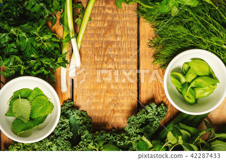 green vegetables and spices in bowls on a wooden table 42287433