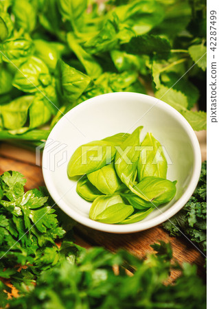 green vegetables and spices in bowls on a wooden table 42287499