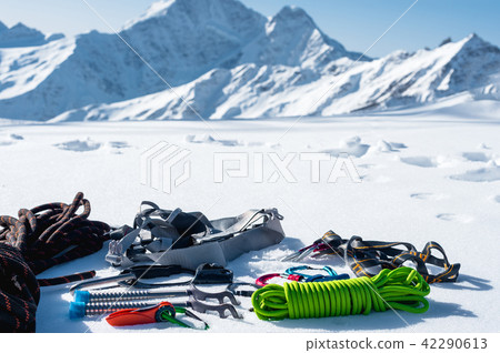 Winter set of equipment of an ice climber with carabiner wounds and a camp thermos against the Winter set of equipment of an ice climber with carabiner wounds and a camp thermos against the 42290613