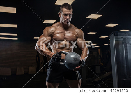 A handsome man in the gym, with a perfect abs, doing weight trai A handsome man in the gym, with a perfect abs, doing weight trai 42291330