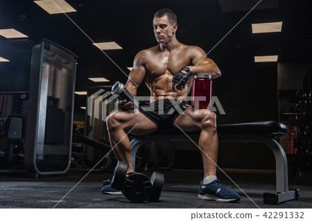 A young handsome man, an athlete bodybuilder, resting after a ha A young handsome man, an athlete bodybuilder, resting after a ha 42291332