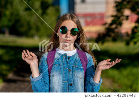 Girl schoolgirl teenager. In the summer in park. The gestures of the hands show surprise. The 42292448