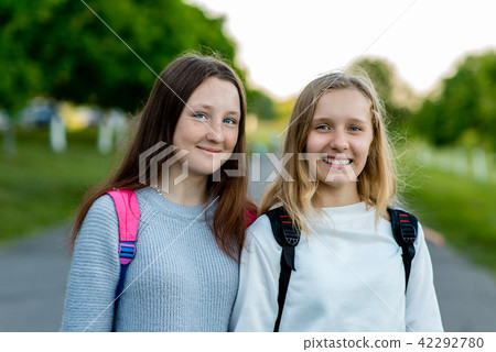 Two girls schoolgirl teenager, in summer after school in nature. To pose on camera. Emotions of joy Two girls schoolgirl teenager, in summer after school in nature. To pose on camera. Emotions of joy 42292780