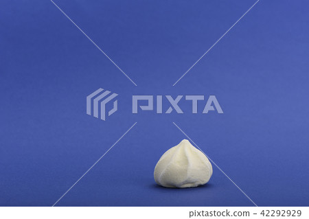 Yellow meringue isolated on blue background Yellow meringue isolated on blue background 42292929