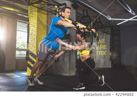 Focused male exercising with instructor Focused male exercising with instructor 42294882