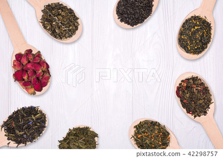 Frame of dry herbal teas in wooden spoons on a white background Frame of dry herbal teas in wooden spoons on a white background 42298757