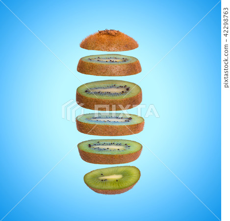 Creative concept with flying kiwi. Sliced kiwi on blue background 42298763