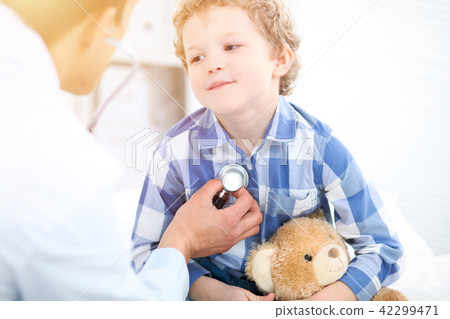 Doctor and child patient. Physician examines little boy by stethoscope. Medicine and children's Doctor and child patient. Physician examines little boy by stethoscope. Medicine and children's 42299471