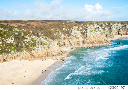 A shallow sandy beach surrounded by rocks and hills On the outskirts of the UK 42300497