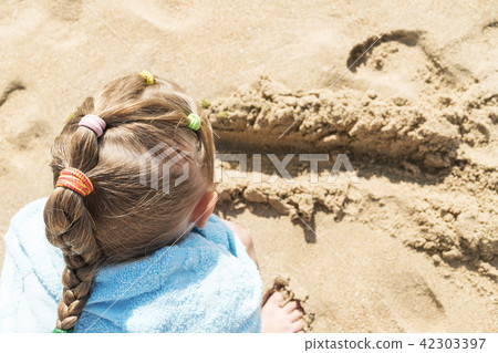 Child is playing in the sand 42303397