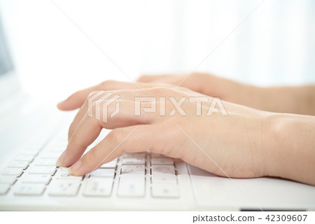 A woman's hand to operate a laptop computer 42309607
