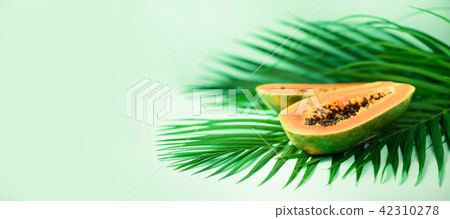 Exotic papaya fruit over tropical green palm Exotic papaya fruit over tropical green palm 42310278