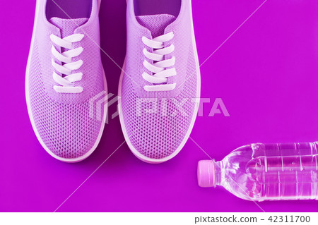 Violet sneakers on a purple background. Violet sneakers on a purple background. 42311700