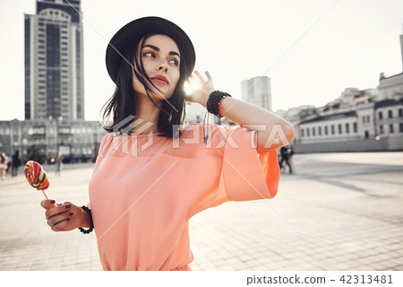 Serene lady keeping candy in hand Serene lady keeping candy in hand 42313481