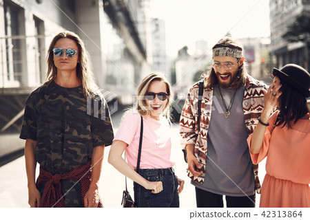 Positive friends walking around street 42313864