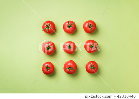 Creative pattern of red tomatos on green 42316446