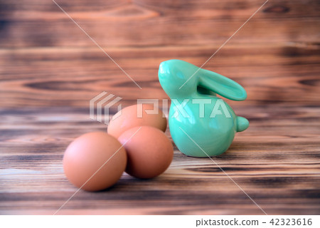 Easter ceramic rabbit with eggs on wooden background. 42323616
