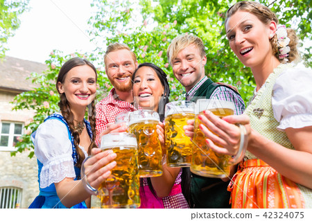 Friends having fun in beer garden while clinking glasses 42324075
