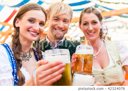 Friends with beer glasses at Bavarian beer tent 42324076