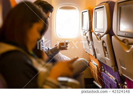 Couple using smartphone in the airplane seat 42324148