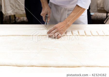 Chef cutting pastry dough with pizza knife Chef cutting pastry dough with pizza knife 42324162