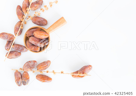 Dates fruit in wooden ladle on white background Dates fruit in wooden ladle on white background 42325405