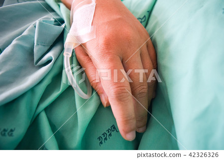 hand on a drip receiving a saline solution hand on a drip receiving a saline solution 42326326