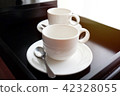 White coffee mug with spoon on black tray 42328055